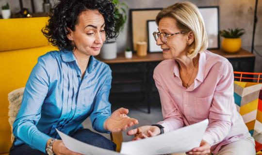 Deux collègues examinent un rapport ensemble.