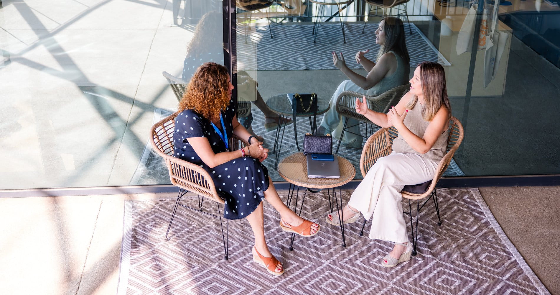 Two female colleagues having a meeting at a small table.