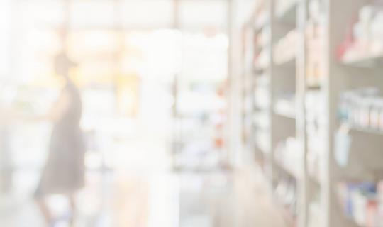 Photo floue d'une personne au comptoir d'une pharmacie