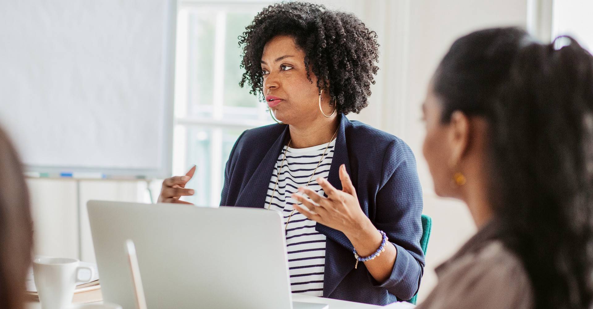 Group of women having a business meeting sitting at a table in an office.