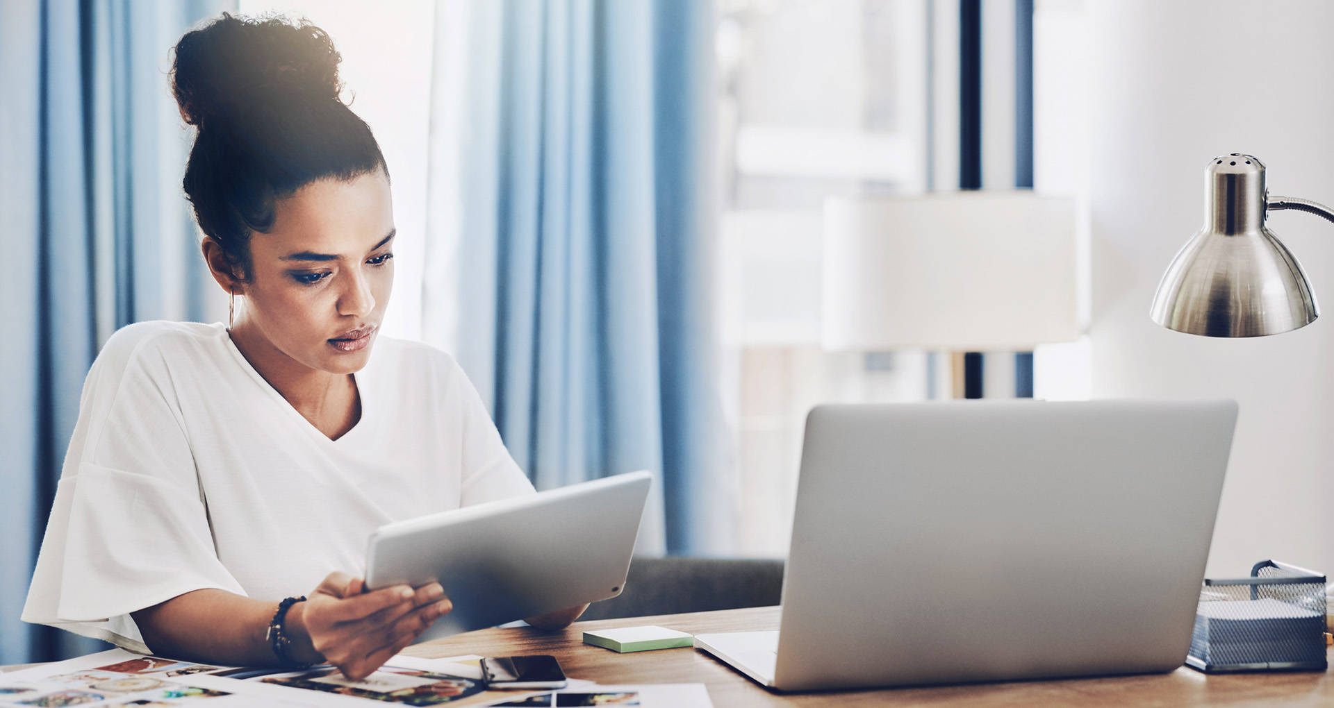 Shot of a young businesswoman using a digital tablet and laptop while working in her home office