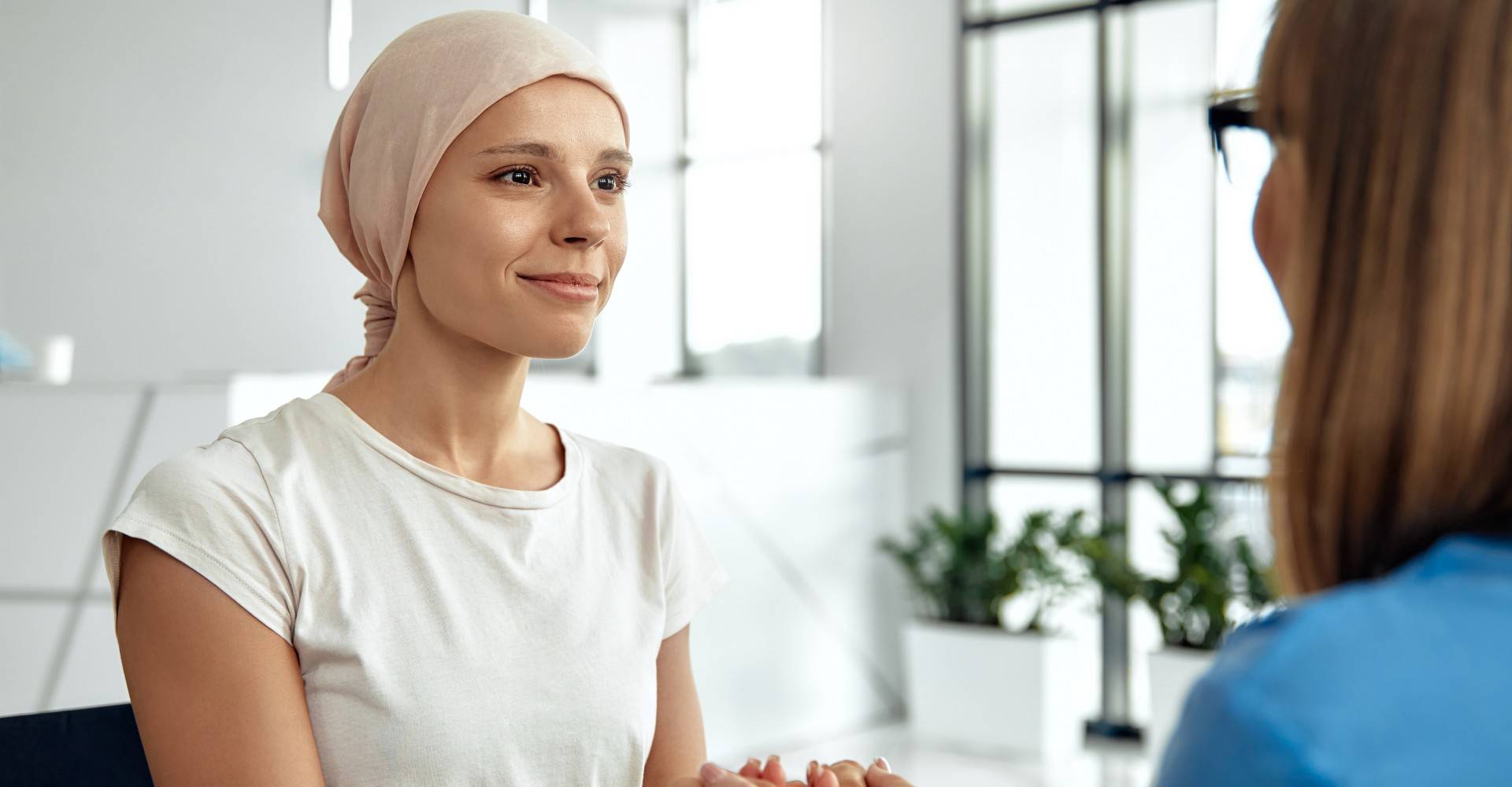 An Oncology patient holding hands with a nurse