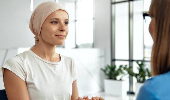 An Oncology patient holding hands with a nurse