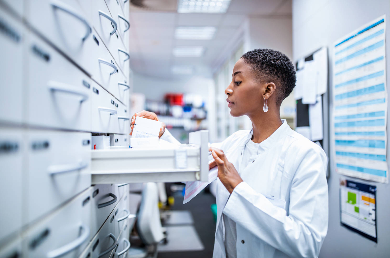 A female pharmacist looking into an opened drawer. 