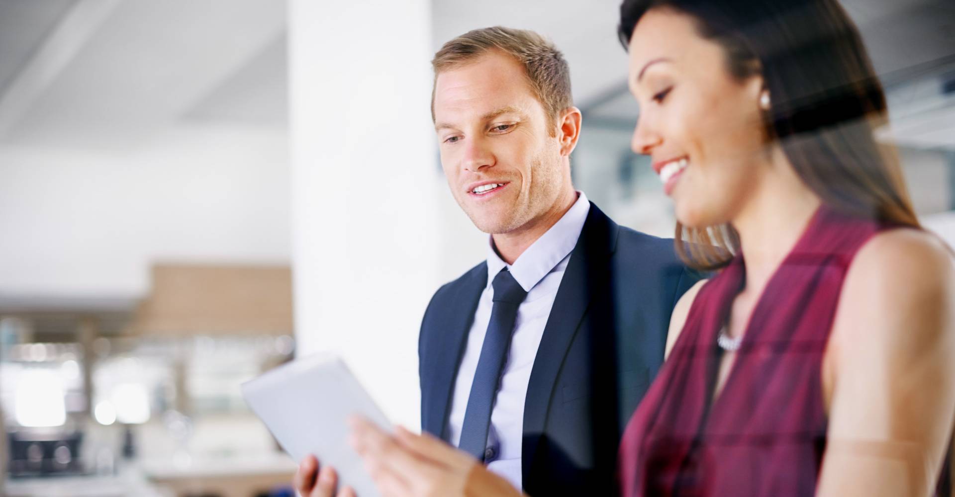 Deux collègues travaillant ensemble sur une tablette numérique dans un bureau