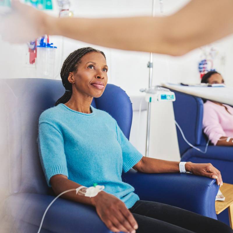 A patient sitting in an infusion chair in a clinic.