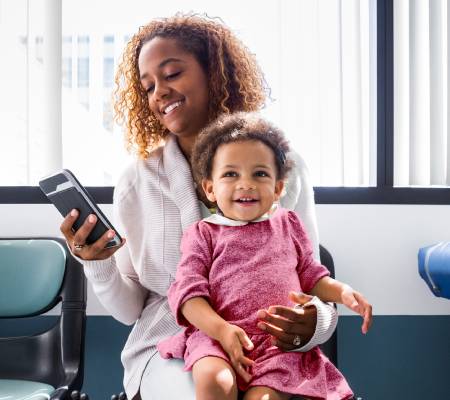 A parent and small child sitting in a waiting room. 