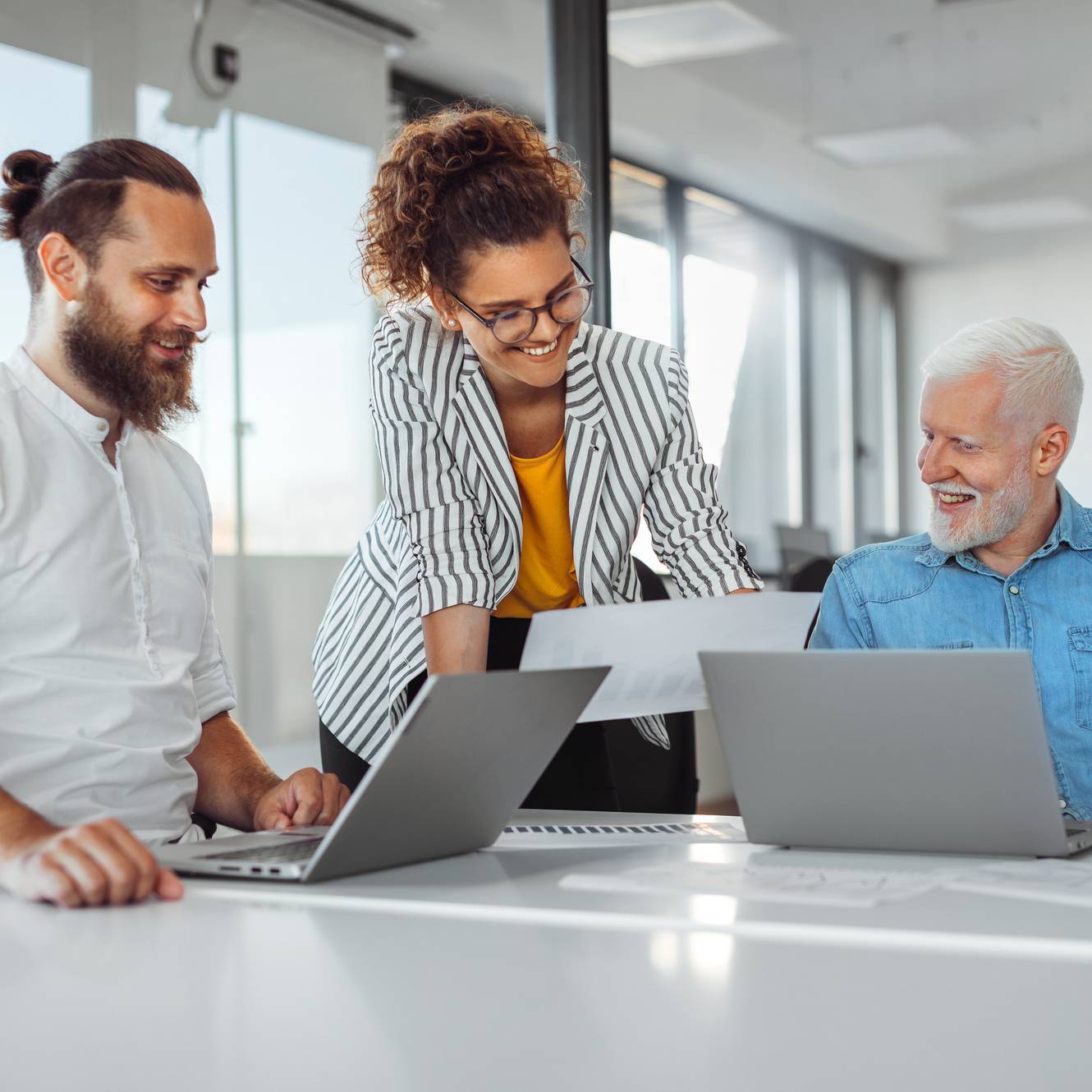 Smiling colleagues reviewing information during a meeting.