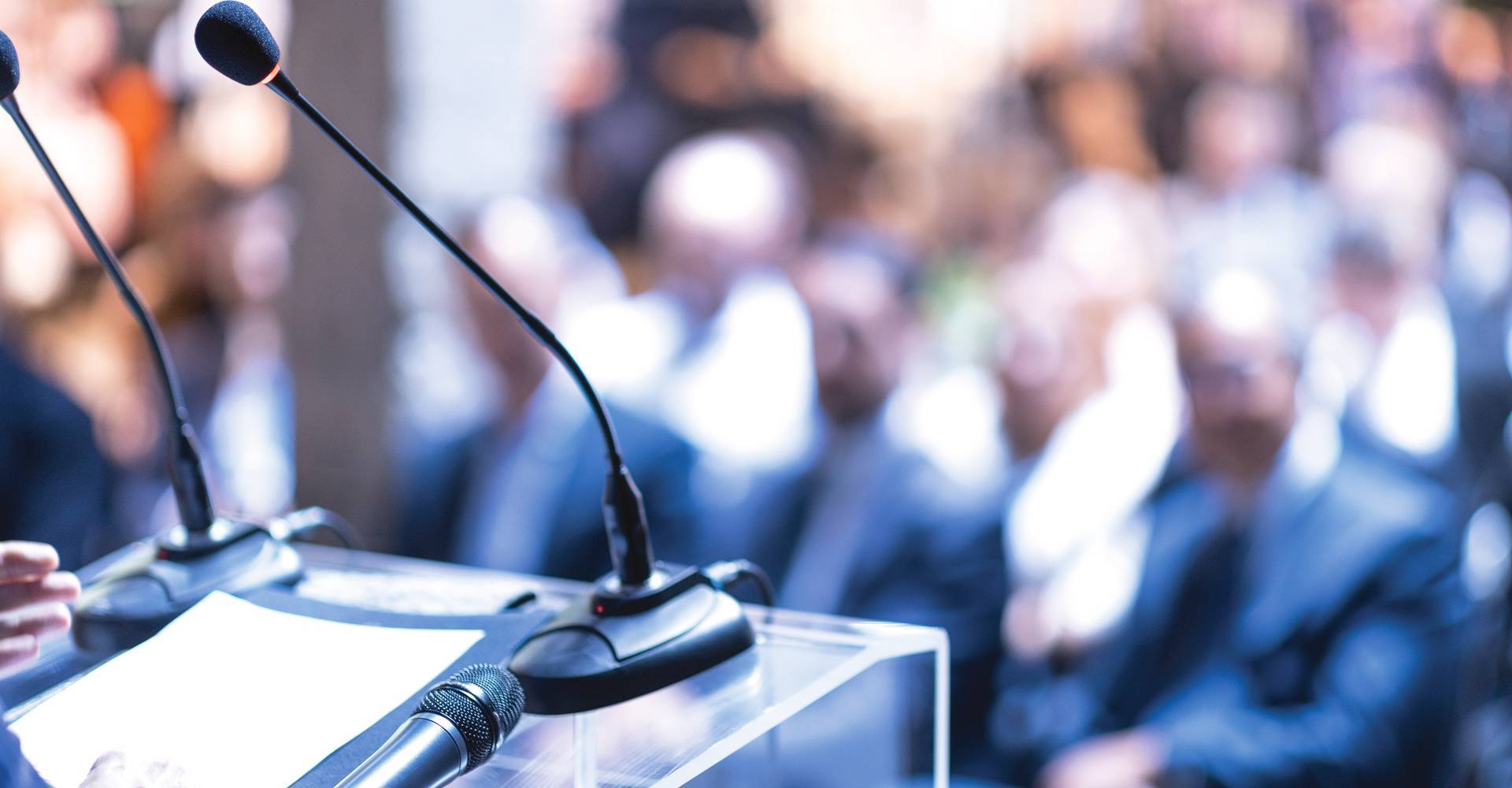 Public speaker at business conference, corporate presentation, workshop, coaching training, news conference, company meeting, public event.